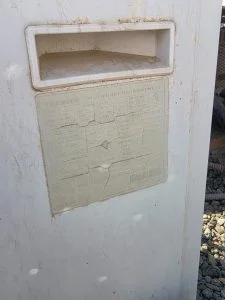 وحدة تكييف هواء قديمة ومتضررة مع ملصق معلومات.